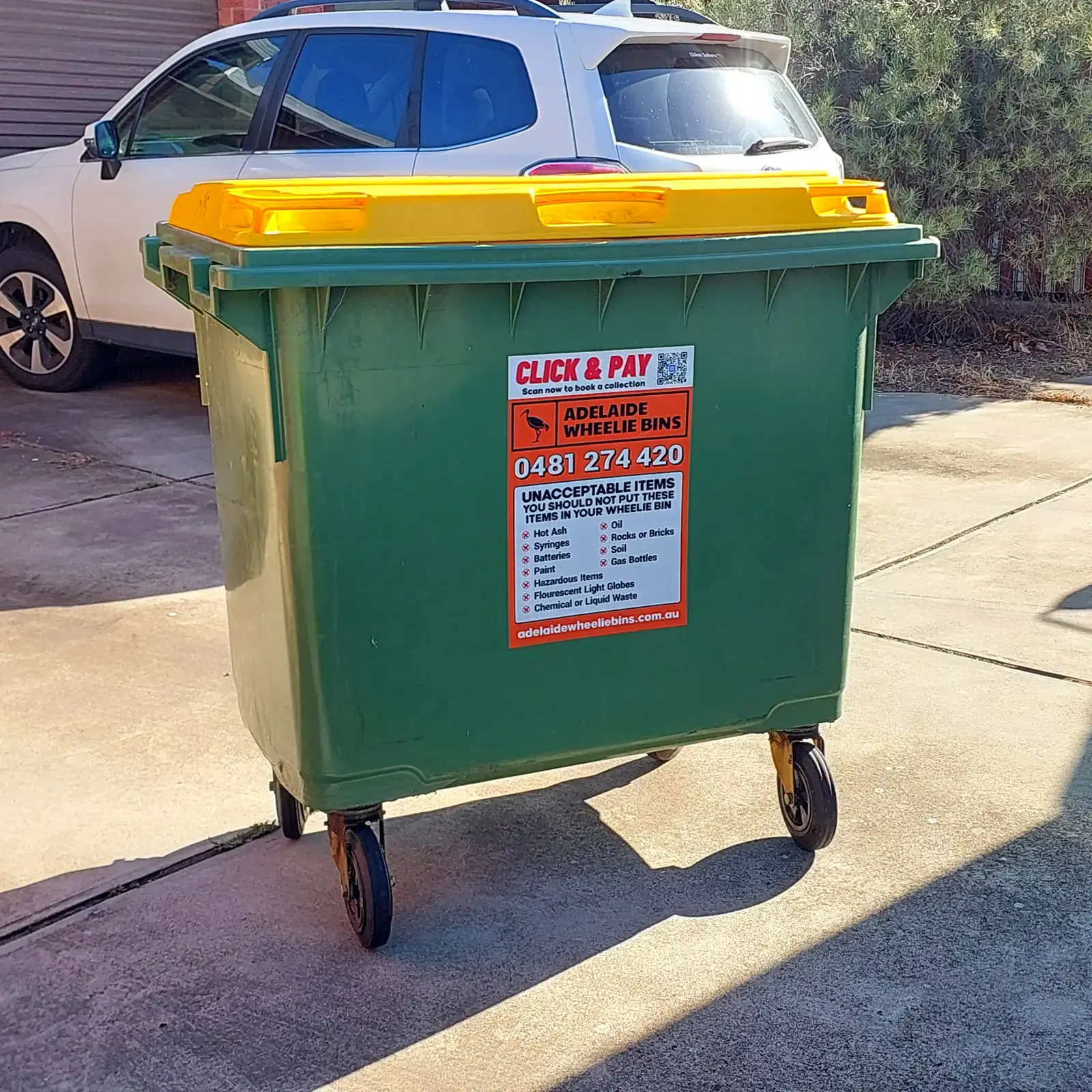 An Adelaide Wheelie Bins 660 litre bin standing on a suburban driveway